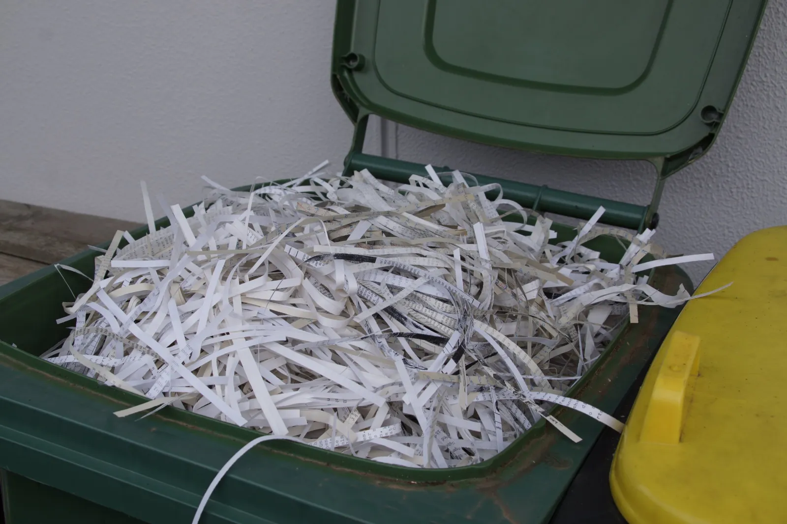 Geschredderte Papierstreifen in einer Papiertonne