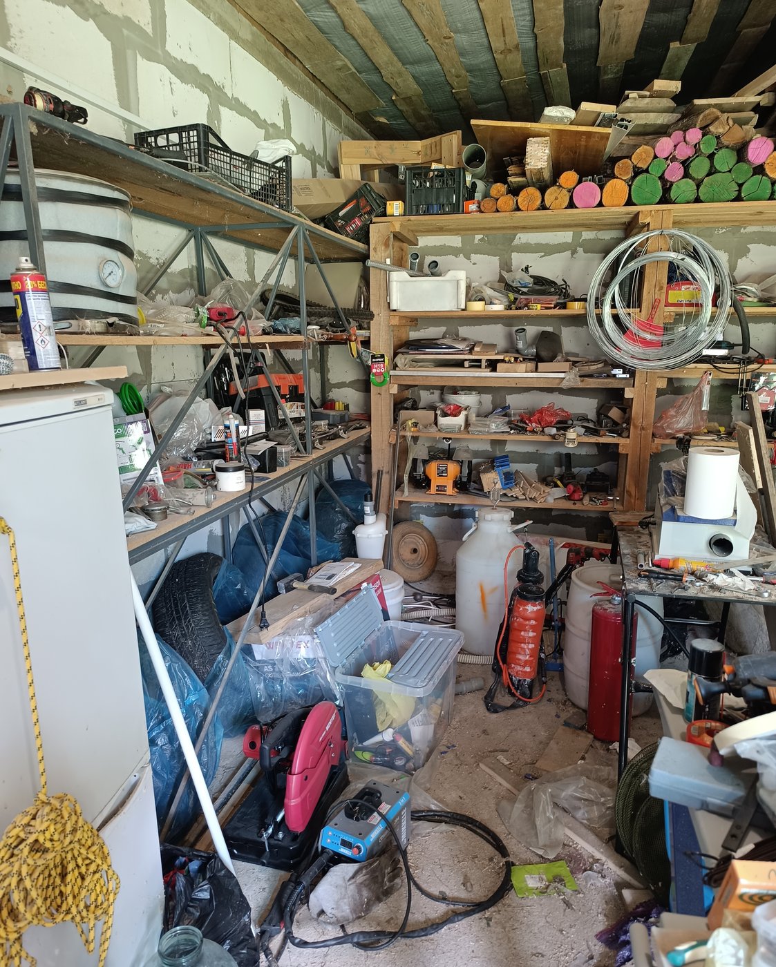 Werkstattgarage mit vollen Regalen, Werkzeug und Kanistern vor der Räumung