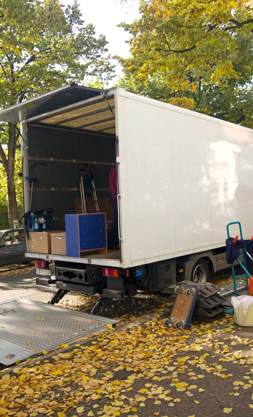 Beladener Lkw mit offener Ladebordwand vor einem Gebäude