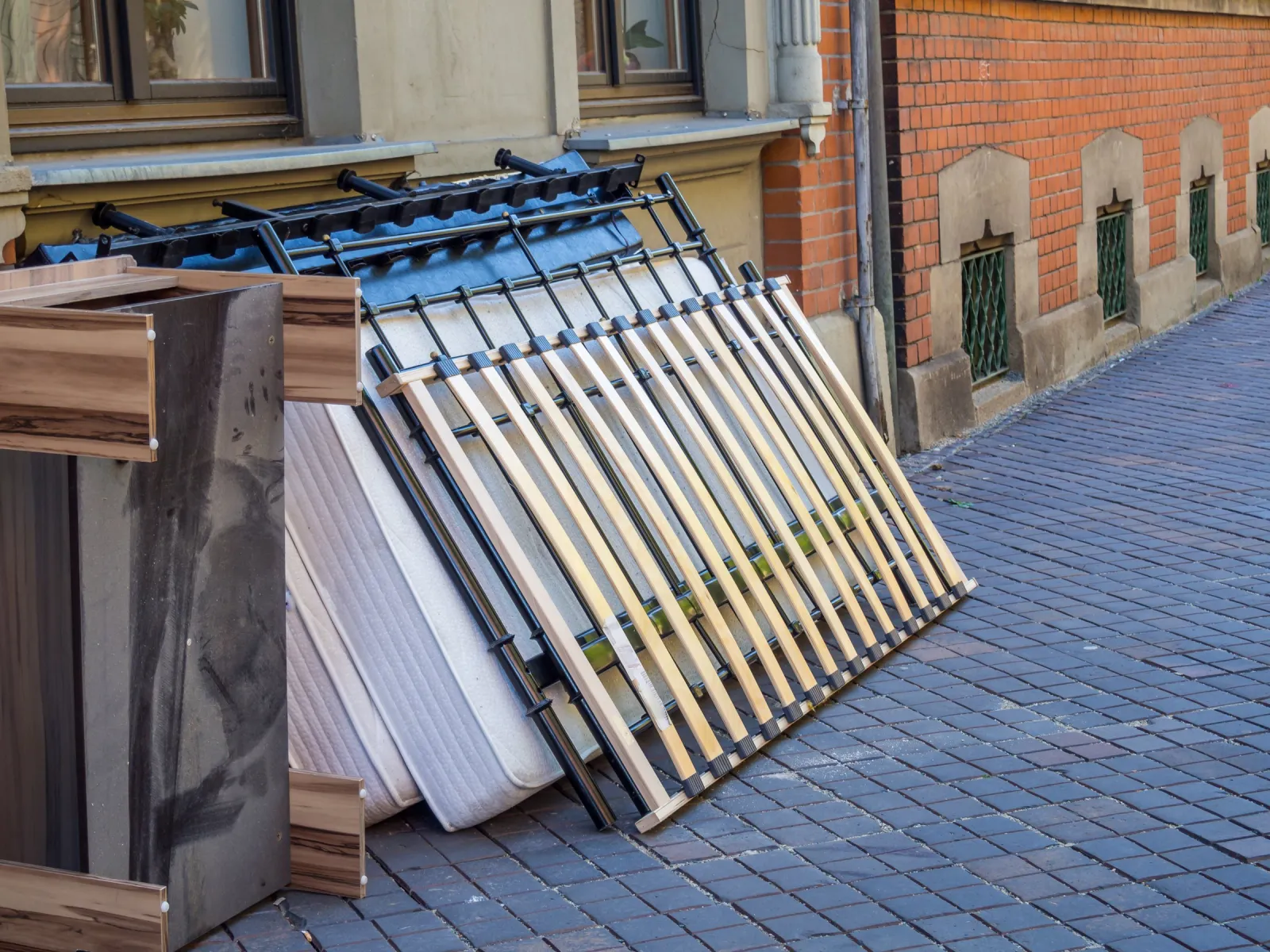 Matratze, Lattenrost und Bettgestell am Straßenrand