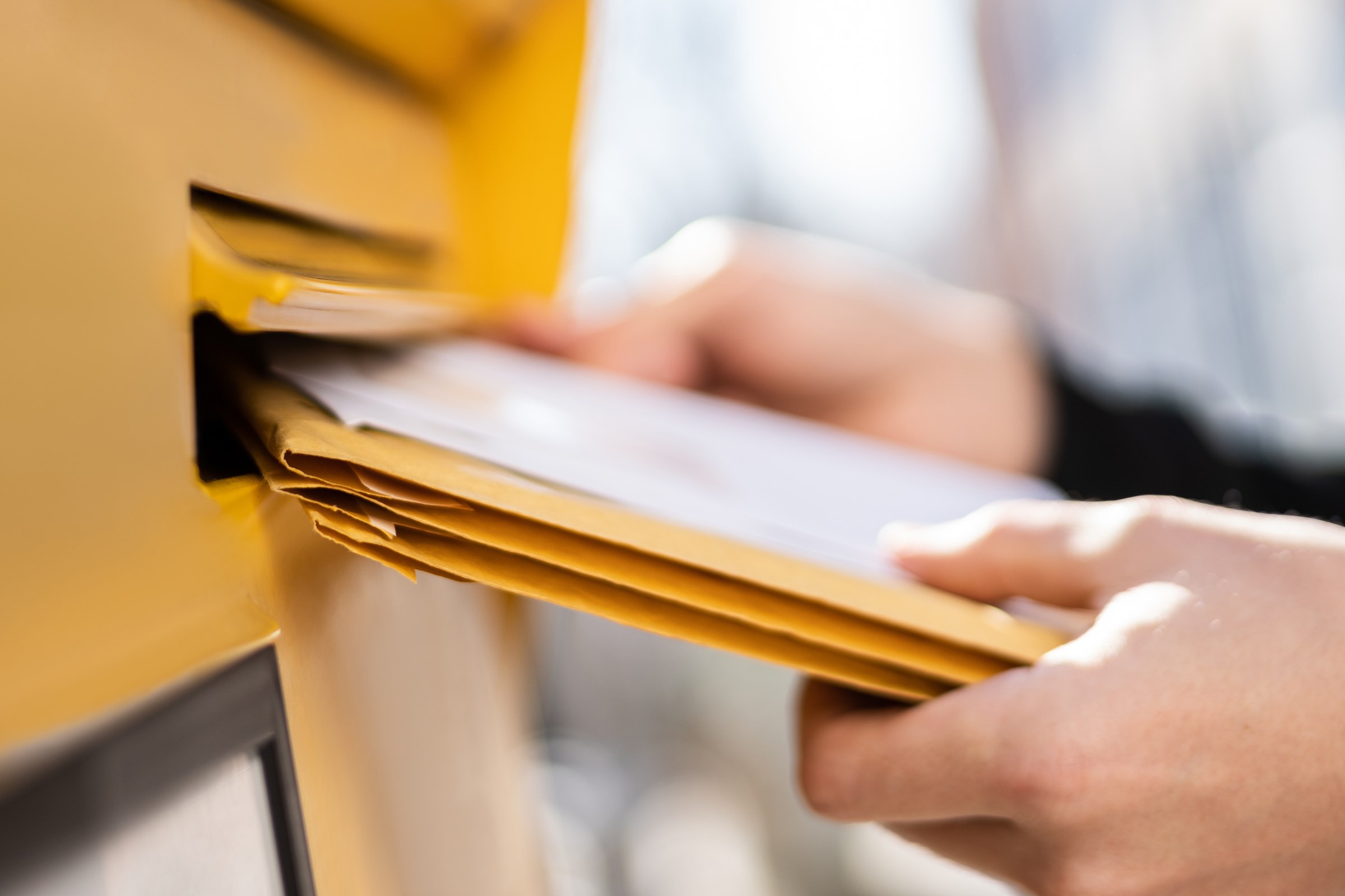 Briefe werden in einen Briefkasten eingeworfen
