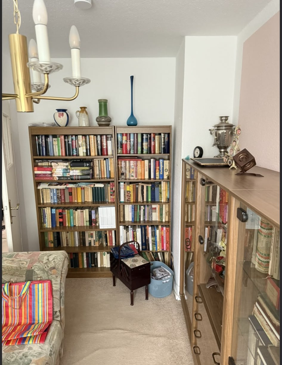 Zimmer mit gefüllten Bücherregalen und Vitrine vor der Räumung