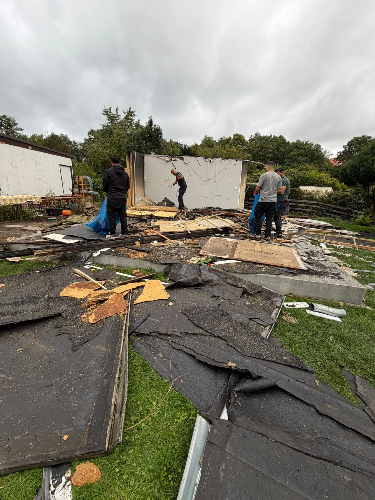 Dachpappe und Holzreste auf dem Grundstück beim Rückbau eines Gartenhauses in Rahnsdorf
